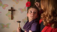 Antonia nagelt ein Kreuz an die Wand und Iffi wundert sich
