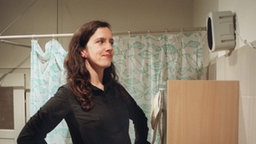 Beate guckt zufrieden in einen Spiegel