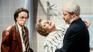 Beim Rundgang mit Herrn Hülsch entdeckt Helga etwas Schreckliches in der Badewanne. (V.l.: Horst A. Scheel, Marie-Luise Marjan, Bill Mockridge)