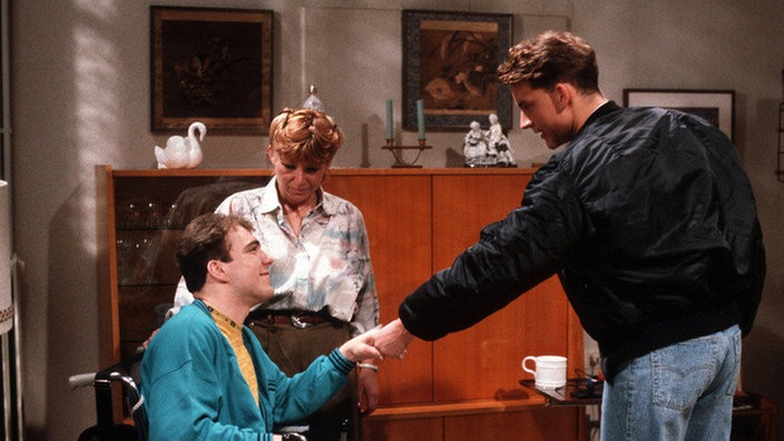 Benny (Christian Kahrmann, rechts) stellt sich als Zivildienstleistender bei Christoph Bogner (Michael Dillschnitter) und dessen Mutter (Jeanette Becker) vor.