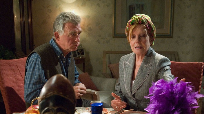 Bruno (Heinz Marecek) hat für Isolde (Marianne Rogée) alle Utensilien zusammengetragen, die sie angeblich von ihrer monatelangen Kreuzfahrt mitgebracht hat.