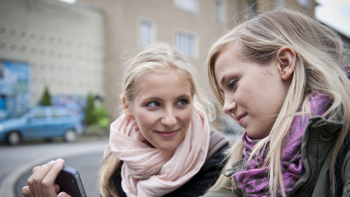 Caro und Lea sitzen auf dem Bügersteig der Lindenstraße