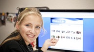 Caro zeigt auf einen Computer