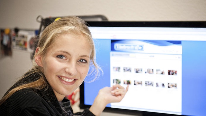 Caro zeigt auf einen Computer