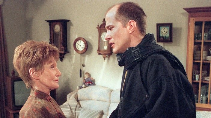 Carsten (Georg Uecker) bittet Rosi (Margret van Munster), die Klage wegen des verpfuschten Armgipses zurückzuziehen.