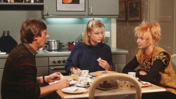 Chris (Stefanie Mühle, rechts) lädt Tanja (Sybille Waury) und Franz (Raimund Gensel) zu einer Mieterversammlung ein.