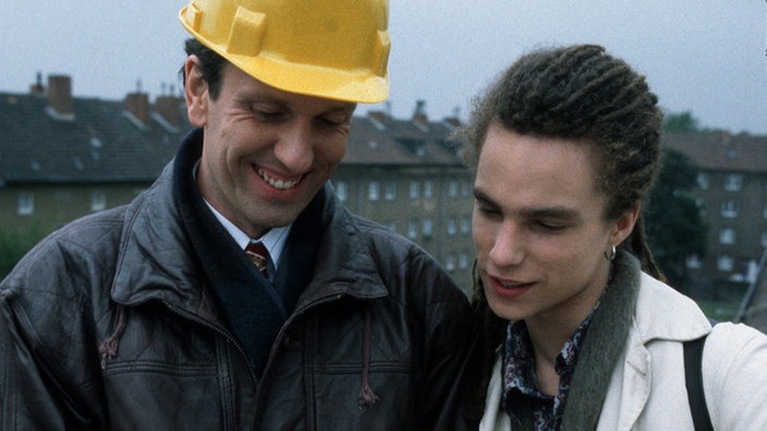 Der werdende Vater Momo (Moritz Zielke, rechts) zeigt dem baldigen Großvater Kurt (Michael Marwitz) voller Stolz ein Untraschallfoto.