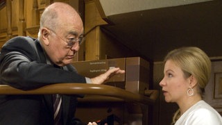 Dr. Dressler (Ludwig Haas) ermahnt Andrea (Beatrice Kaps-Zurmahr) eindringlich, niemandem etwas über die Hintergründe ihrer Kündigung zu erzählen.