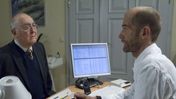 Dr. Dressler (Ludwig Haas, links) lässt nicht locker: Er bedrängt Carsten (Georg Uecker) weiterhin, Hannelore als Sprechstundenhilfe einzustellen.