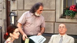 Dr. Dressler (Ludwig Haas) und Beate (Susanne Gannott) fühlen sich durch Panaiotis' fordernde Spendenaufrufe beim Essen gestört.