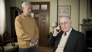 Dr. Dressler telefoniert neben Gung