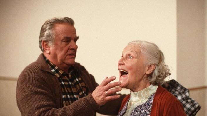 Egon (Wolfgang Grönebaum) greift zur Selbsthilfe. Else (Annemarie Wendl) will das ganze Haus zusammenschreien.