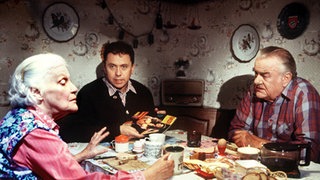 Egon (Wolfgang Grönebaum, rechts) muss mit ansehen, wie Else (Annemarie Wendl) ihren Sohn Olaf (Franz Rampelmann) mit einer freizügigen Illustrierten provoziert.