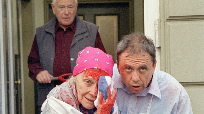 Else (Annemarie Wendl) und Olaf (Franz Rampelmann, rechts) lehnen die Hilfsangebote von Oskar (Reinhold Lampe) ab. Kein Wunder: Sie haben etwas sehr Peinliches zu verbergen.