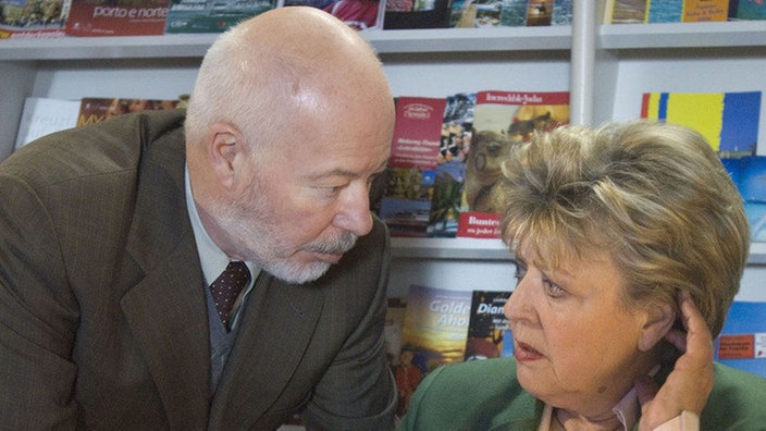 Erich (Bill Mockridge) erklärt der verunsicherten Helga (Marie-Luise Marjan) erneut, dass man ihr Hörgerät auf keinen Fall sieht.