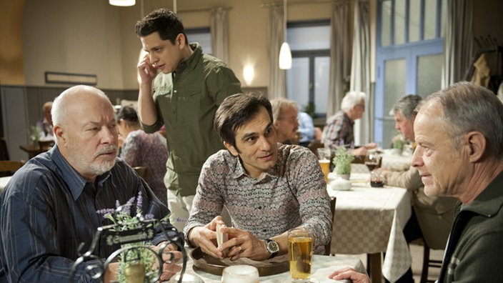 Erich, Vasily und Hajo sitzen im restaurant "Akropolis", Enzo telefoniert