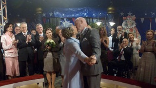 Erst das Ja-Wort, dann der Kuss: Helga (Marie-Luise Marjan) und Erich (Bill Mockridge) heiraten zum zweiten Mal – diesmal im Zirkus. Freunde und Nachbarn haben als Überraschung das Zirkuszelt samt Programm gemietet.