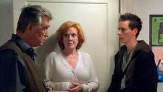 Fabian (Roman Haubner, rechts) bringt Bruno (Heinz Marecek) eine teure Flasche Wein als Geschenk vorbei. Isolde (Marianne Rogée) ist davon alles andere als angetan.
