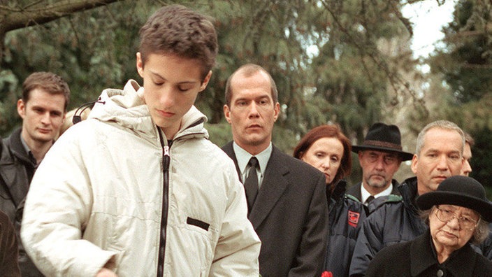 Fassungslos steht Felix (Marc-Oliver Moro, vorne links) am Grab seiner Mutter.