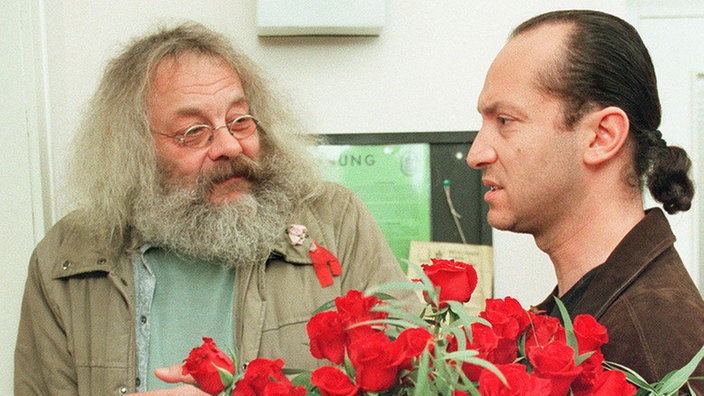 Fausto (Antonio Paradiso, rechts) klingelt vergeblich bei Isolde. Harry (Harry Rowohlt) erweist sich als dankbarer Abnehmer der nun unnützen Rosen.