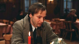 Firedhelm sitzt depromiert im Restaurant