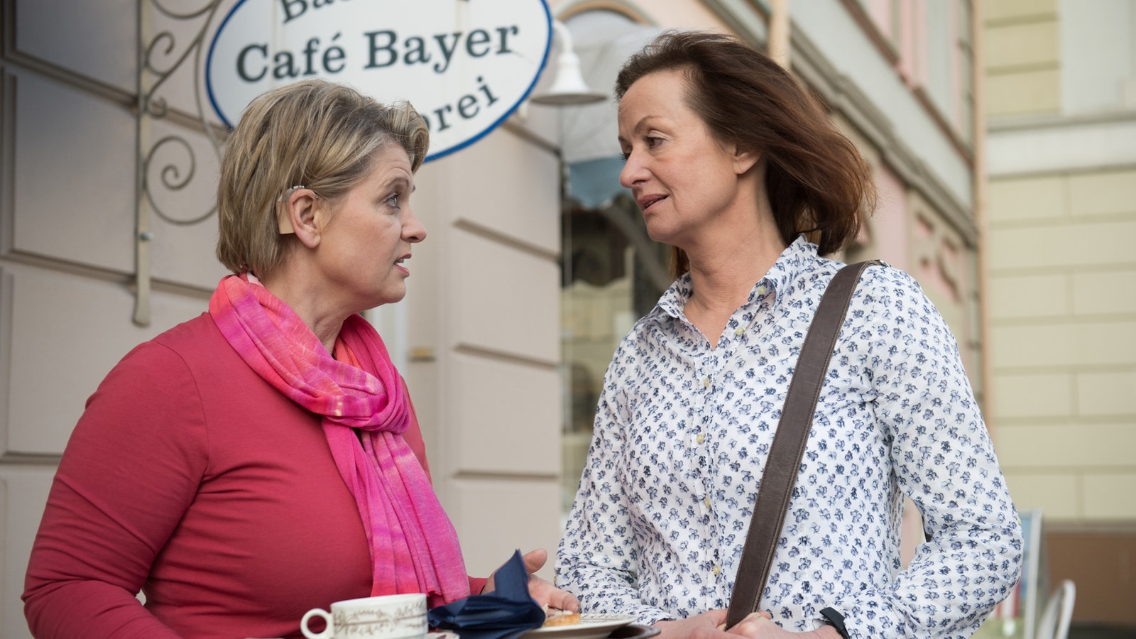 Gabi und Anna unterhalten sich vorm Café Bayer