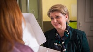 Gabi zeigt Iffi einen Karton Gebäck