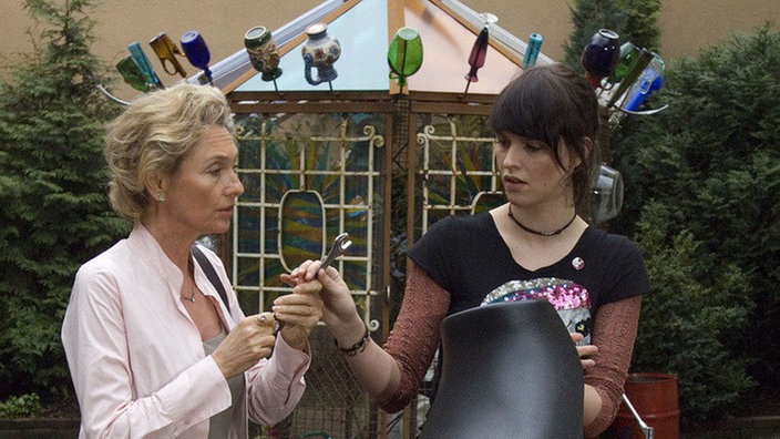 Hanne (Wookie Mayer, links) will Jack (Cosima Viola) dazu bewegen, sich wieder mit Dressler zu vertragen. Jack handelt rasch und lädt die beiden zur Teatime in den Hinterhof ein.