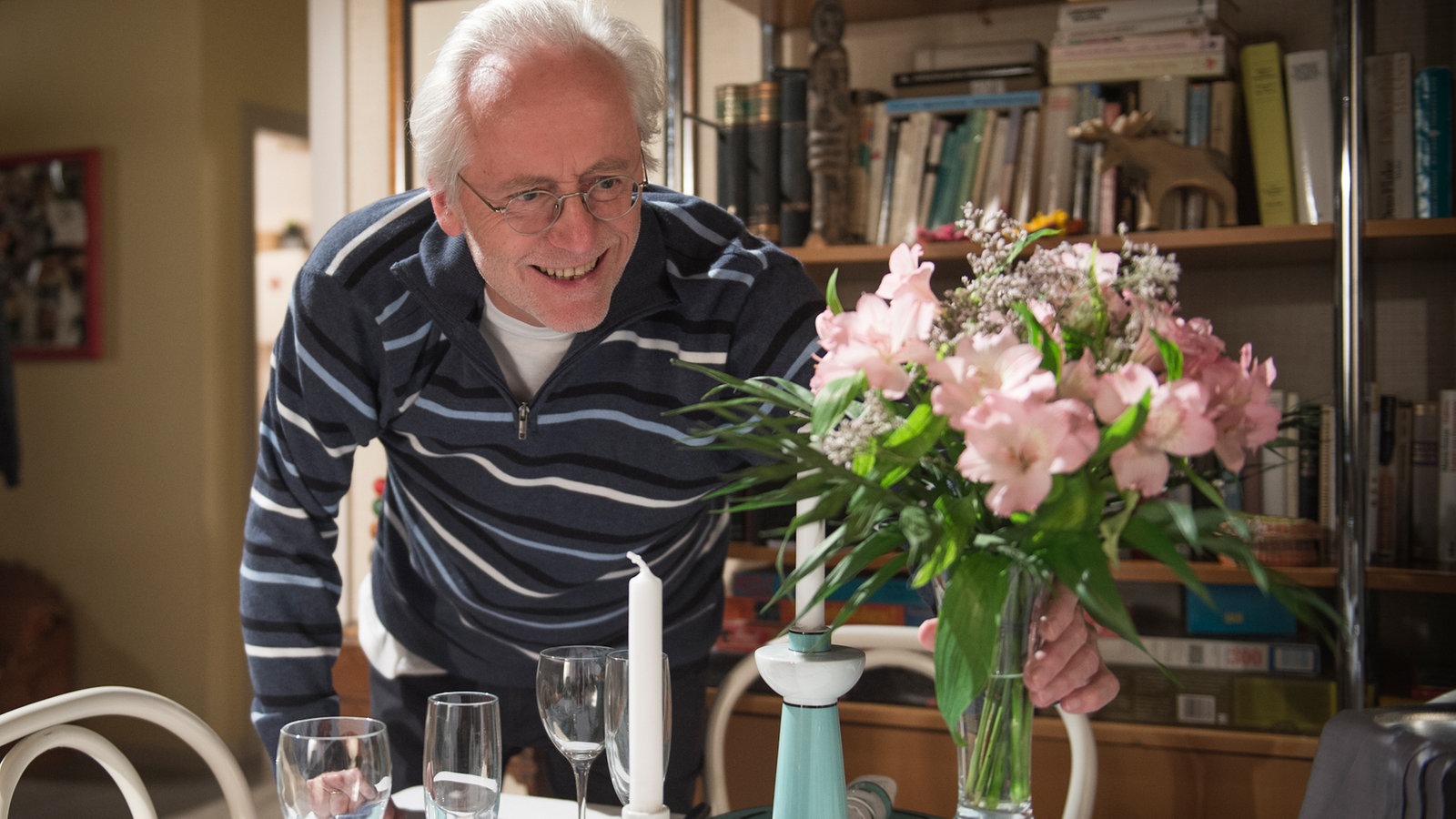 Hans deckt den Tisch mit Blumen