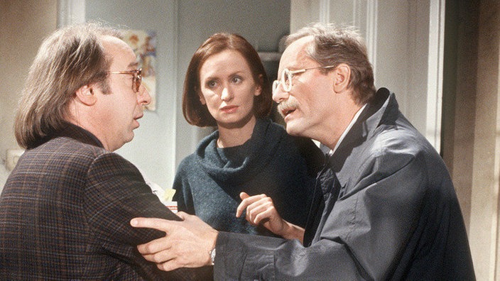 Hans erkennt den Makler, der ihm vor Jahren schon einmal ein marodes Haus verkauft hat. (V.l.: Joachim Hermann Luger, Irene Fischer und Richard Rogler)