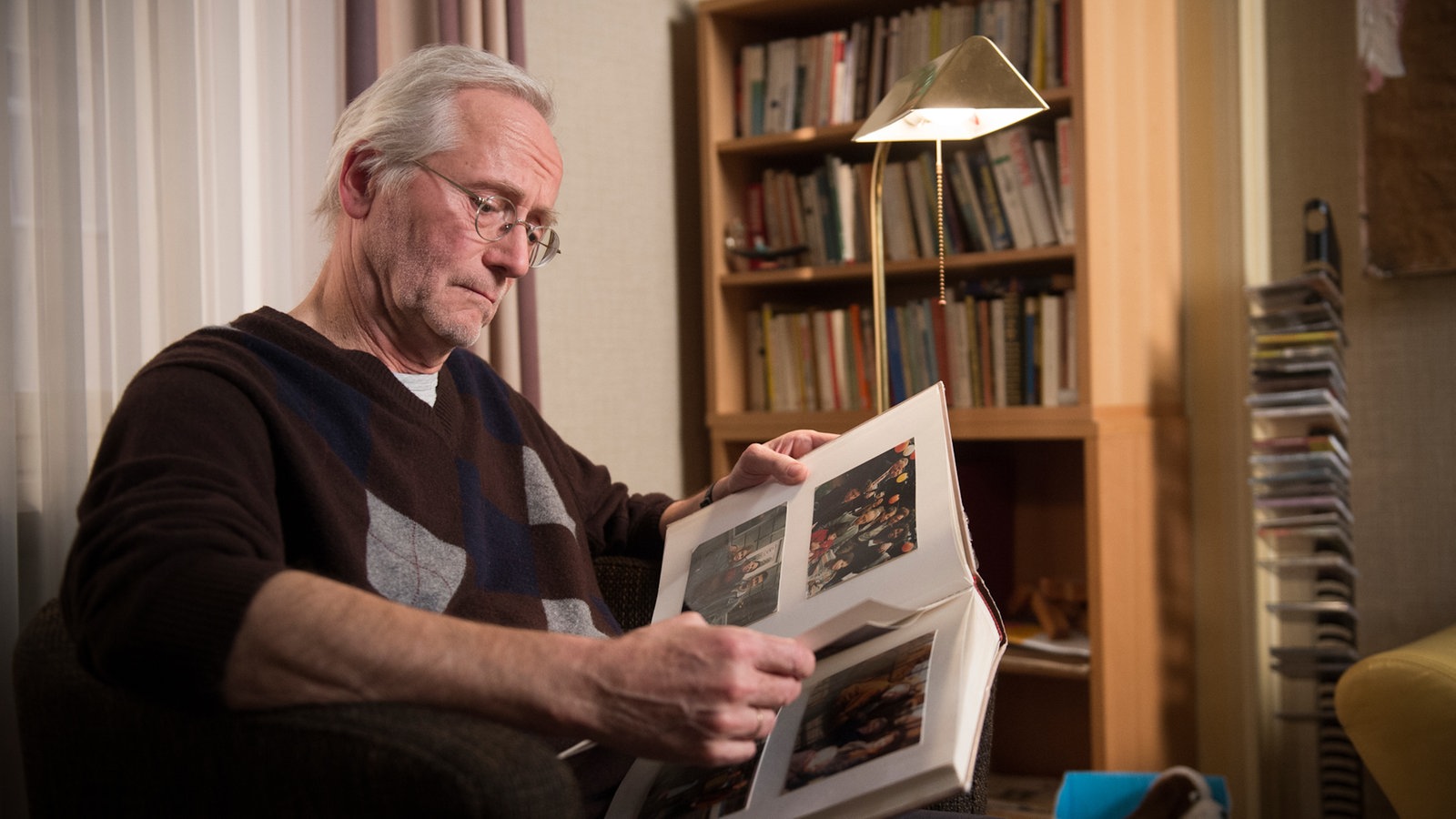 Hans guckt sich ein Fotoalbum an