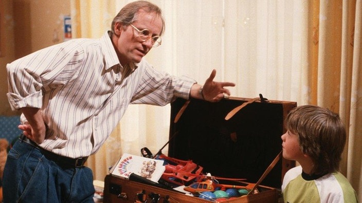 Hans (Joachim Hermann Luger, links) erklärt Klausi (Moritz A. Sachs), dass er leider nicht mit in den Urlaub fahren kann.
