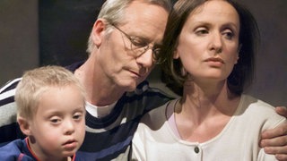 Hans (Joachim Hermann Luger) redet Anna (Irene Fischer) zu, trotz der Probleme mit Sarah zur Arbeit zu fahren (links: Jan Grüning).