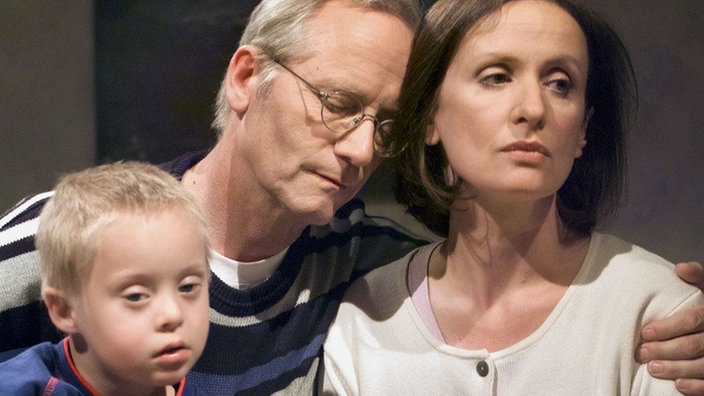 Hans (Joachim Hermann Luger) redet Anna (Irene Fischer) zu, trotz der Probleme mit Sarah zur Arbeit zu fahren (links: Jan Grüning).