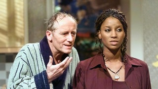 Hans (Joachim Hermann Luger) spricht Mary (Liz Baffoe) ins Gewissen: Sie soll ihre Ehe mit Vasily nicht leichtfertig aufs Spiel setzen.