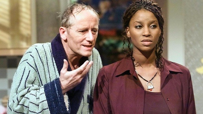 Hans (Joachim Hermann Luger) spricht Mary (Liz Baffoe) ins Gewissen: Sie soll ihre Ehe mit Vasily nicht leichtfertig aufs Spiel setzen.