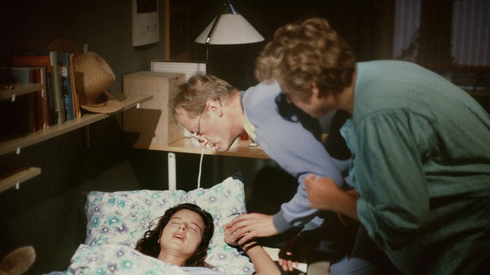 Hans (Joachim Hermann Luger) und Helga (Marie-Luise Marjan, rechts) sind ratlos: Was geht nur in Dominique (Brigitte Annessy) vor?