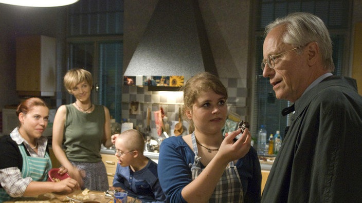 Hans (Joachim Luger, rechts) probiert die Pralinen, die Steffi (Isabell Brenner, 2.v.l.) mit Sarah (Julia Stark, links), Mürfel (Jan Grünig) und Sophie (Dominique Kusche) gemacht hat.