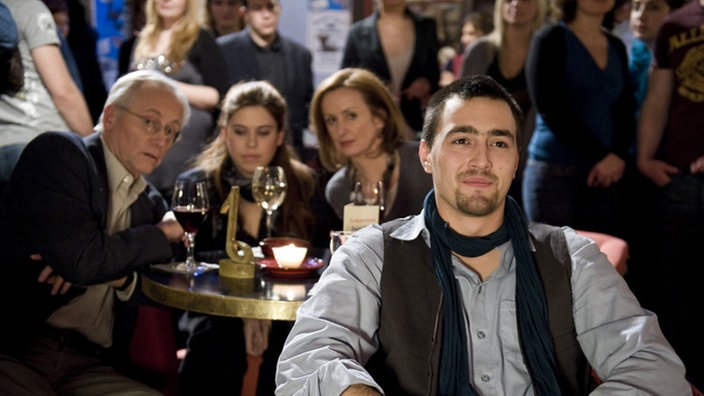 Hans, Sarah, Anna und Tom sitzen im Club "Schneerot"
