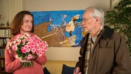 Hans schenkt Anna Blumen