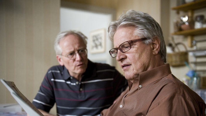 Hans und Andy blättern in Unterlagen