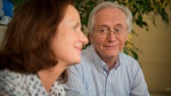 Hans und Anna sitzen nachdenklich auf dem Sofa