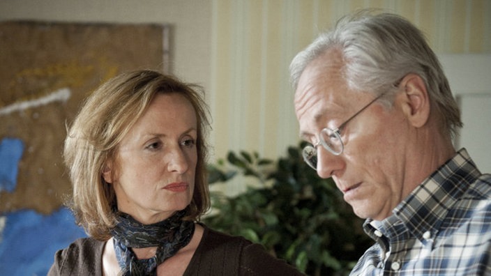 Hans und Anna stehen im Wohnzimmer