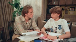 Hans und Benny sitzen im Wohnzimmer
