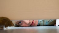Helga entdeckt Mäuse unter dem Schreibtisch im Reisebüro