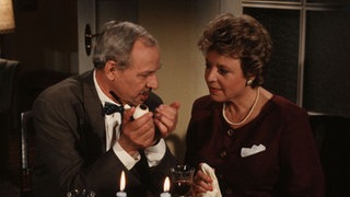 Helga (Marie-Luise Marjan) lädt Herrn Eisenbeiß (Helmut Everke), den sie über eine Kontaktanzeige kennengelernt hat, zum Abendessen ein.