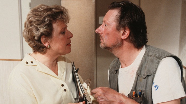 Helga (Marie-Luise Marjan) motiviert die Nachbarn (Raimund Gensel) gegen die geplante Mieterhöhung anzukämpfen.