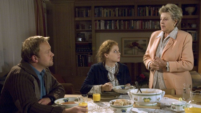 Helga (Marie-Luise Marjan, rechts) hat Nastya (Anja Antonowicz) und Klaus (Moritz A. Sachs) zum Essen eingeladen – nicht ohne Hintergedanken. Ihr ist die Beziehung seit langem ein Dorn im Auge.
