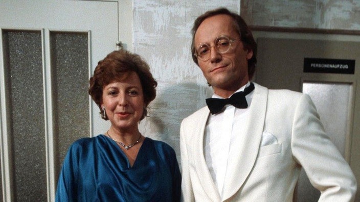 Helga (Marie-Luise Marjan) und Hans (Joachim Hermann Luger) auf dem Weg zur Party von Hans' neuem Arbeitgeber.
