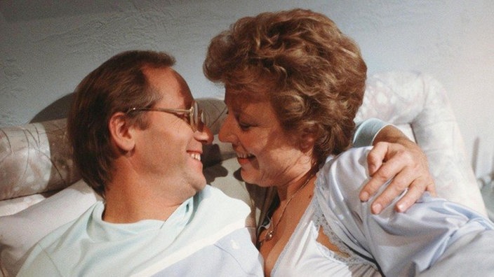 Helga (Marie-Luise Marjan) verführt den gipslosen Hans (Joachim Hermann Luger).